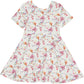 knee length twirl dress with short sleeves and scoop neckline, in traditional festival bunting and pink tent print on a white background, made of bamboo fabric